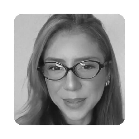depoimento-gabrielle-azevedo-psicologa-omicha.jpg Retrato da psicóloga Gabrielle Azevedo, mulher jovem de cabelos avermelhados longos, usando óculos, sorrindo suavemente para a câmera em depoimento para a OMICHA.