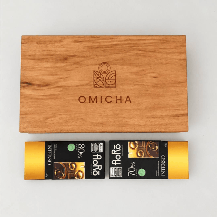 conteudo-kit-aureo-chocolates-aoro-omichas.gif Animação em loop demonstrando o conteúdo do Kit Áureo em estojo de madeira sustentável OMICHA, composto por chocolates intensos Bean to Bar da marca Aorô, chás orgânicos e Roda de Sabores.