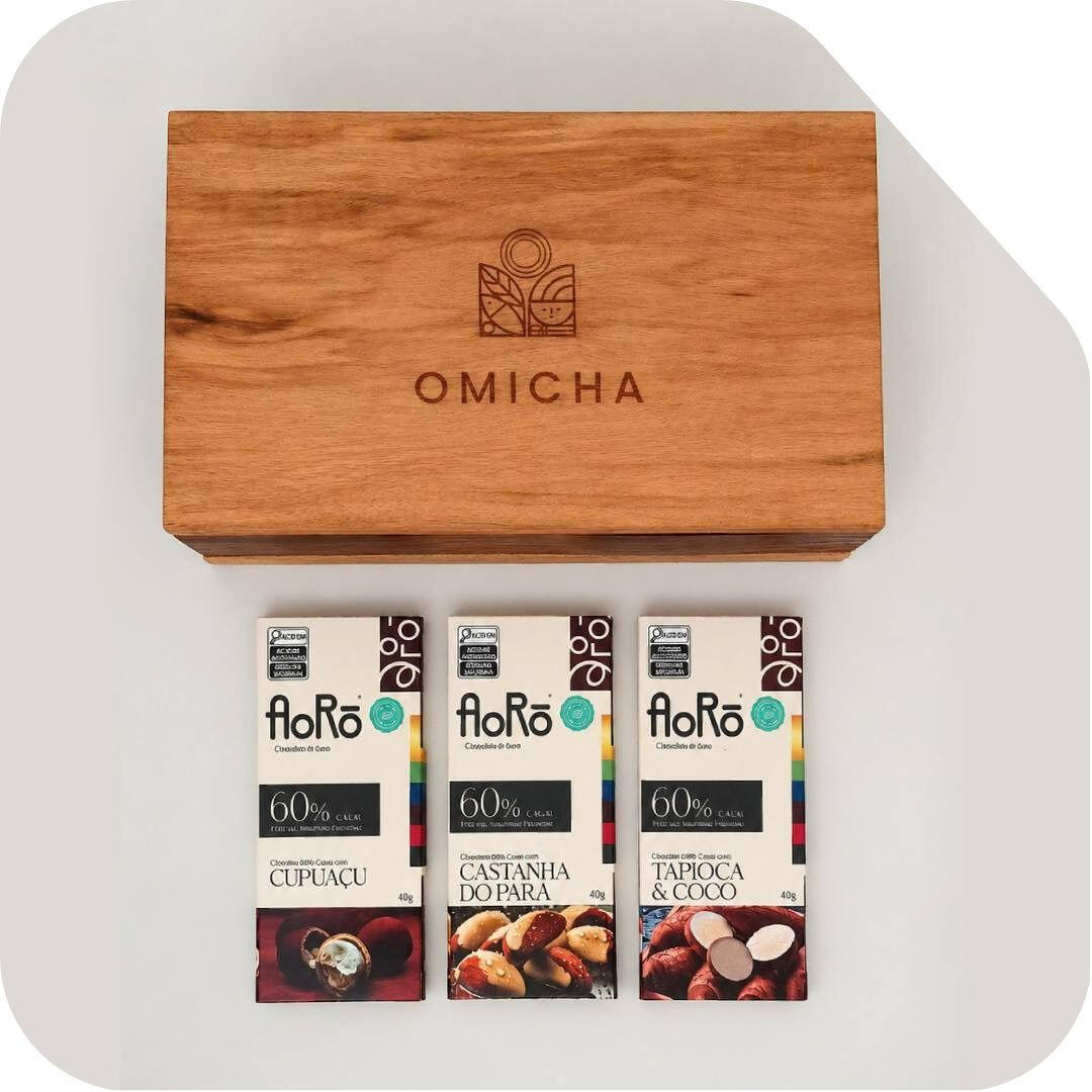 estojo-omicha-chocolates-aoro-60-cacau-cupuacu-castanha-tapioca.jpg Estojo de madeira Omicha com barras de chocolate Aorô 60% cacau nos sabores Cupuaçu, Castanha do Pará, e Tapioca e Coco.